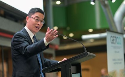 Professor Xiwang Zhang at the launch of GETCO2 at UQ. A man stands at a lectern with his hand raised.